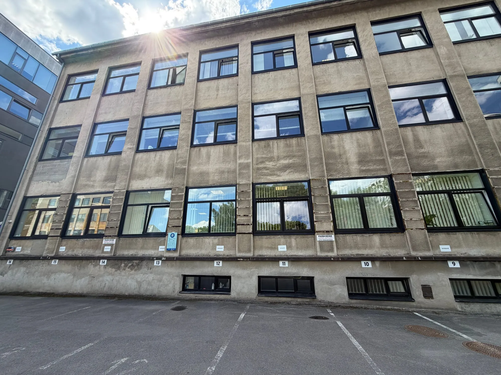 Värskelt pestud akendega vanem kontorihoone Katusepapi 4 sisehoovis, taustaks sinine taevas