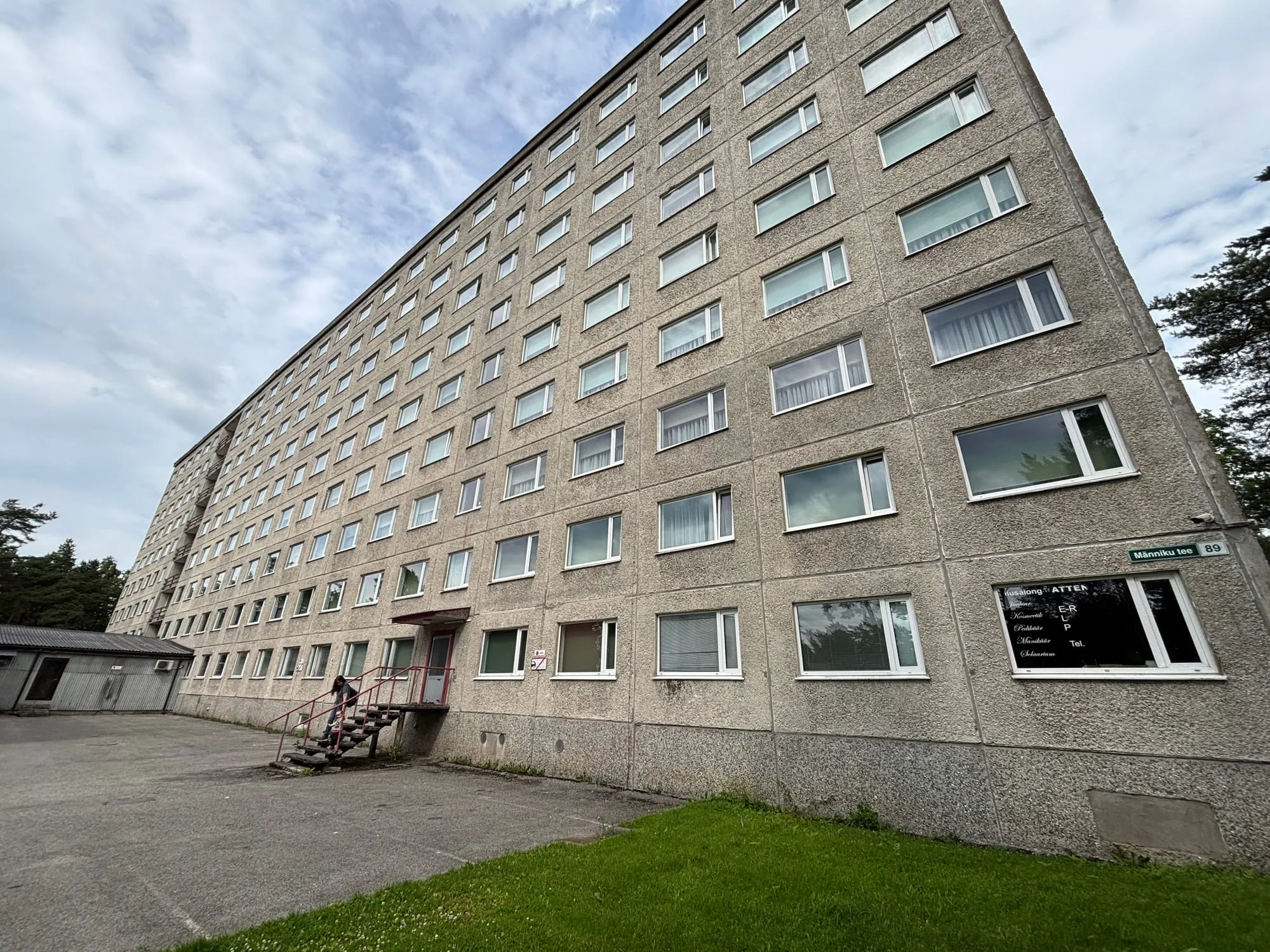 Männiku tee 89 pikk paneelfassaad aadressisildiga — kõrghoone akende välipesu objekt