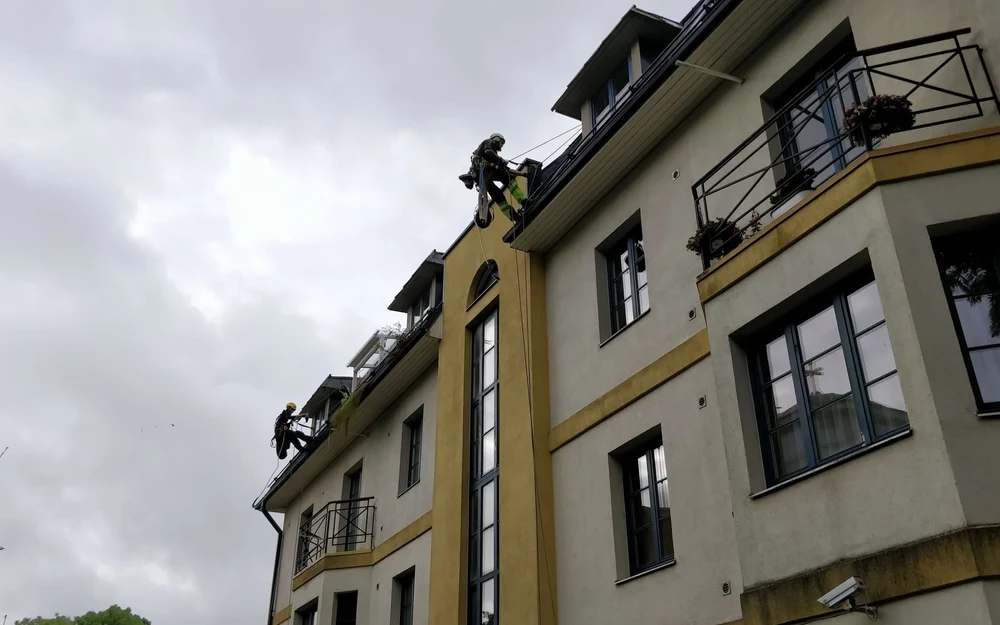 Skyproffi köietehnikud puhastavad kõrgel hoonel vihmaveerenne